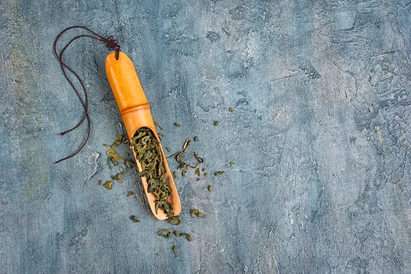 Kopya alanı mavi beton zemin üzerine yeşil çayın bambu kepçe içinde üstten görünüm