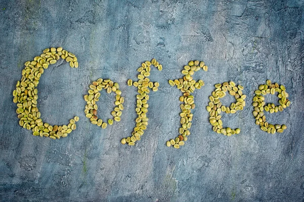 Draufsicht Auf Schriftzug Mit Rohen Grünen Kaffeebohnen Auf Blauem Betongrund — Stockfoto