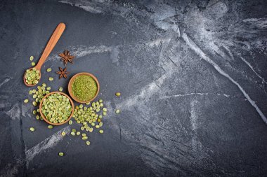 Ahşap kase ve anason yıldız kopya alanı siyah mermer zemin üzerine kaşıkla üstten görünüm ham yeşil yeşil kahve fasulye yer