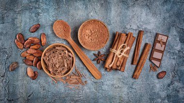 Çikolata parçaları, bar ve kakao tozu mavi beton zemin üzerine şekerlemeler için baharat ile üstten görünüm