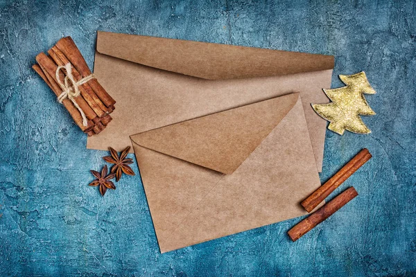 青の具体的背景に黄金の木とスパイスのクリスマス カードに挨拶するため空白の茶色の封筒の上から見る — ストック写真