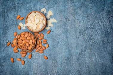 En iyi görünümü kopya alanı mavi beton zemin üzerine şekerlemeler için madde olarak ahşap kase bütün fındık ve badem dilimleri