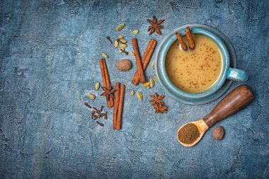 Geleneksel Hint içki masala chai çay süt ve tarçın sopa, yeşil kakule, anason star, kopya alanı mavi beton zemin üzerine Hindistan cevizi ile üzerinde üstten görünüm