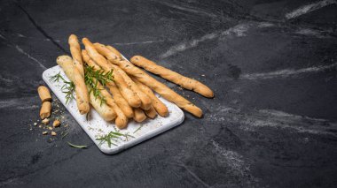 Geleneksel İtalyan meze grisini ile biberiye baharat kopya alanı siyah mermer zemin üzerine beyaz ahşap tahta üzerinde