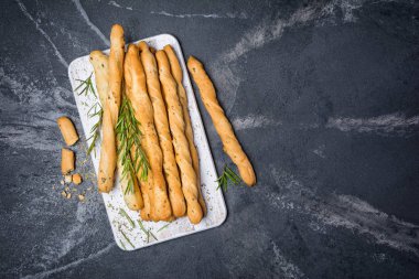 Geleneksel İtalyan meze grisini biberiye baharat ile üstten görünüm kopya alanı siyah mermer zemin üzerine beyaz ahşap tahta üzerinde