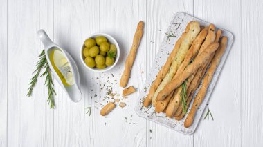 Geleneksel İtalyan meze grisini biberiye baharat ve zeytinyağında sauceboat üstten görünüm Beyaz ahşap zemin üzerinde