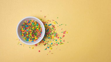 Üstten görünüm parlak renkli şeker şeker veya konfeti dekor kopya alanı altın zemin üzerine kabartma olarak beyaz kase