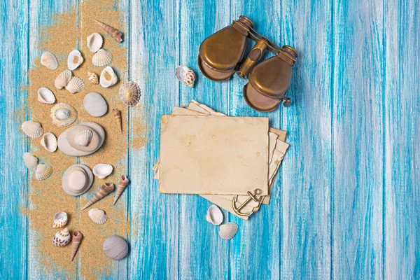 Deniz kum ve mavi ahşap arka plan üzerinde ile mock-up vintage fotoğraf kartları ve dürbün üzerinde Üstten Görünüm