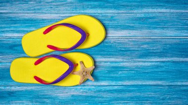 Tatil zamanı kavramı olarak denizyıldızı ile parlak sarı parmak arası terlik