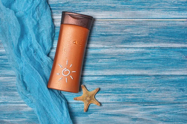 Butelka z filtrem przeciwsłonecznym z rozgwiazdy na błękitnej gazy biegacza stołu jako pojęcie czasu wakacji — Zdjęcie stockowe