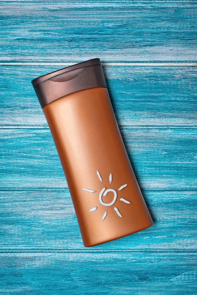 Bouteille de bronze avec écran solaire sur fond bleu comme concept de temps de vacances — Photo