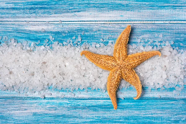 Sea salt crystals and starfish on blue background — Stock Photo, Image