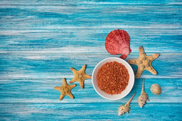Cristaux de sel de mer pour le bain avec étoiles de mer et coquillages sur bleu — Photo