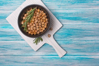 Biberiye ile siyah kase kavrulmuş tuzlu ve baharatlı nohut üzerinde üst görünümü