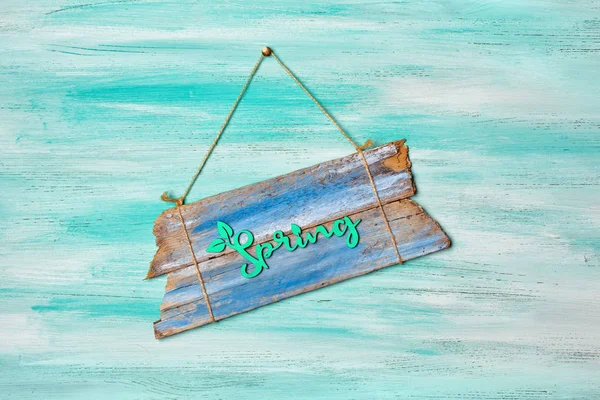 Vintage blue wooden signboard with green word of spring hanging by rope — Stock Photo, Image