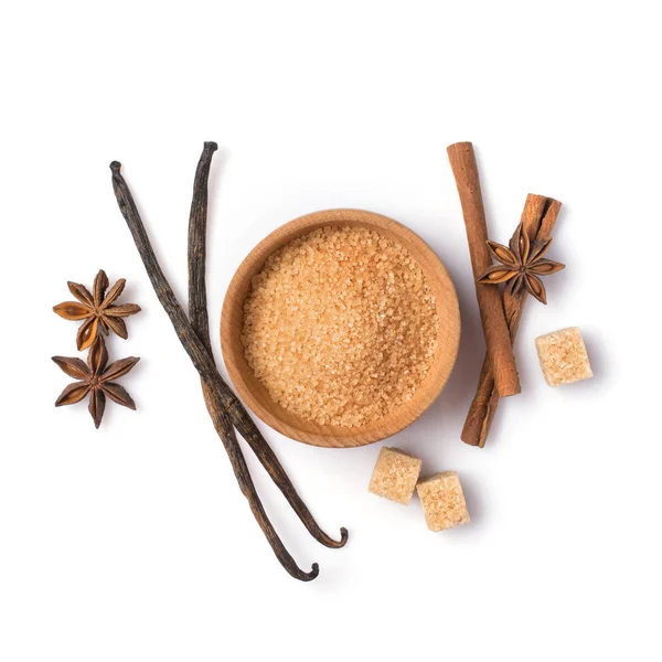 Caña marrón granulada y cubos de azúcar en cuenco de madera con especias — Foto de Stock