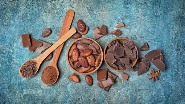 Vista superior em pedaços de chocolate e grãos de cacau para confeitaria — Fotografia de Stock