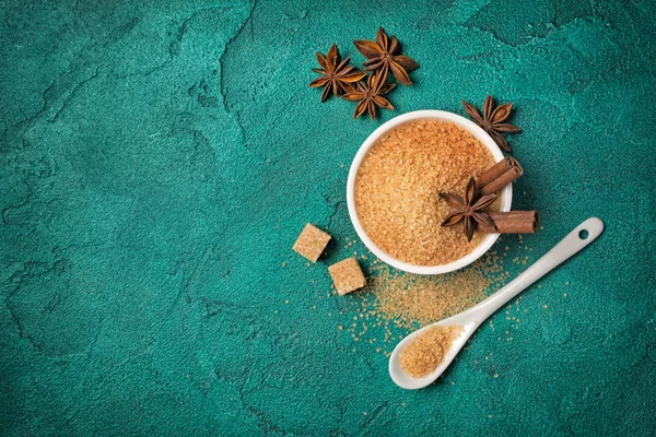 Brown cane granulated and cubes sugar in white bowl with spices — Stock Photo, Image