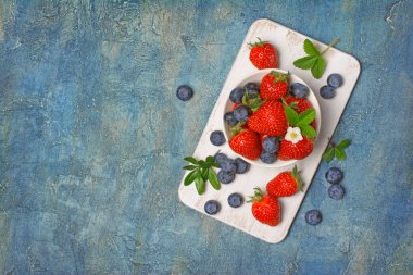 Taze çilek çilek ve yaban mersini yaprakları ve çiçek ile