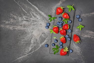 Taze çilek çilek ve yaban mersini yaprakları ve çiçek ile