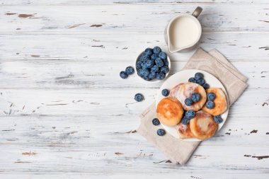 Beyaz ahşap arka plan üzerinde yaban mersini ile Süzme peynir krep