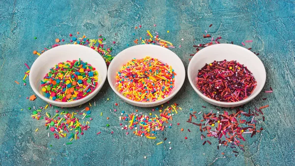 Espolvoreos de azúcar de colores brillantes o confeti como decoración para hornear —  Fotos de Stock