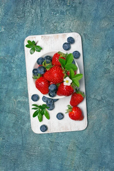 Frische Beeren Erdbeeren und Blaubeeren mit Blättern und Blüten — Stockfoto