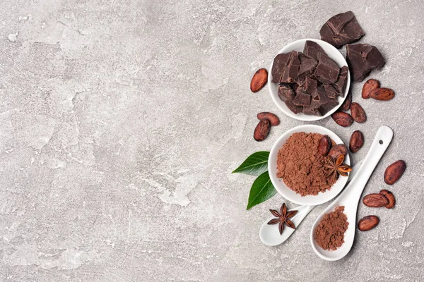 Widok z góry na ziarna kakaowca i proszek z kawałkami czekolady do wyrobów cukierniczych — Zdjęcie stockowe