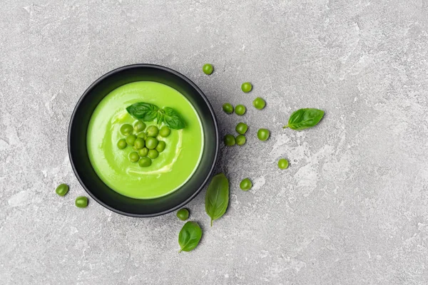 Soup of young green peas with basil leaves on gray — Stock Photo, Image