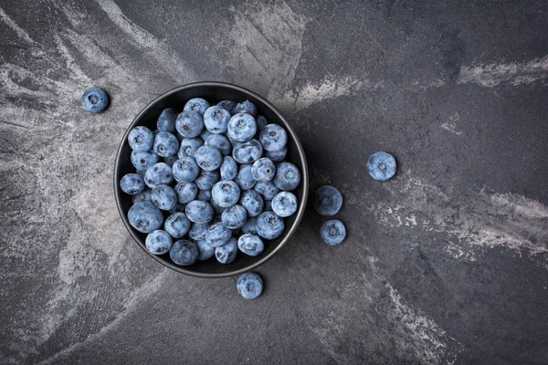 Frische Blaubeeren in schwarzer Schüssel — Stockfoto