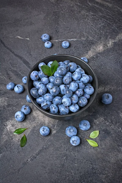Färska blåbär bär i svart skål — Stockfoto