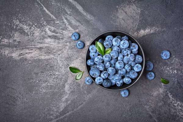 Fresh blueberry berries in black bowl — Stock Photo, Image