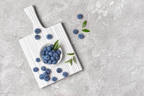 Färska blåbär bär i vit skål på trä kartong — Stockfoto