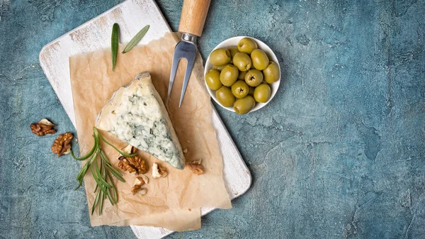 Zachte blauwe kaas met rozemarijn, noten en groene olijven — Stockfoto