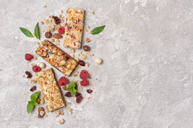 Taze ahududu ve kopya alanı ile gri beton arka plan üzerinde sağlıklı beslenme için fındık karışımı ile granola enerji çubuğu üst görünümü