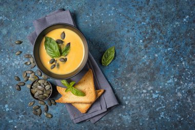 Bir kase vejetaryen kabak çorbası, tohum ve tost.