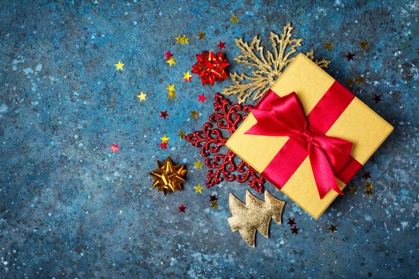 金礼盒，上有闪亮的红色缎子弓，圣诞装饰品 — 图库照片