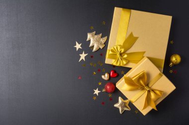 Parlak saten fiyonklu altın hediye kutuları ve Noel süslemeleri.