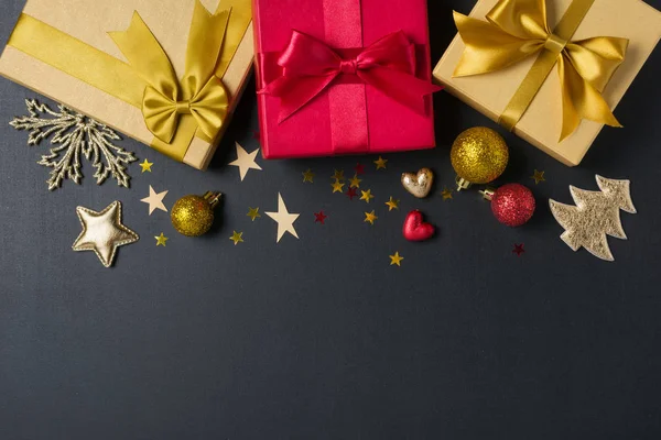 Zlaté a červené dárkové krabice s lesklým saténovým lukem a vánoční ozdobou — Stock fotografie