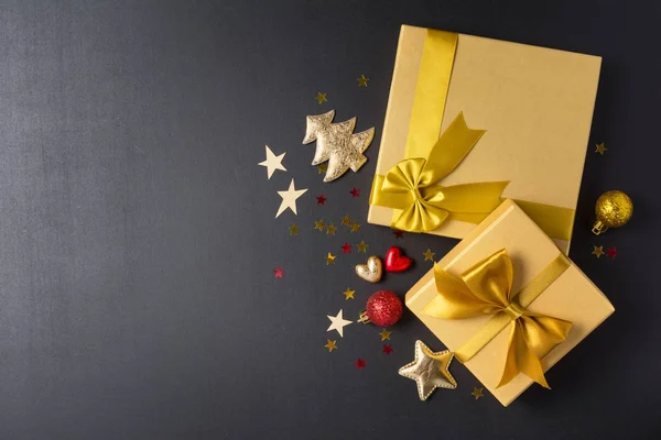Cajas de regalo de oro con brillante lazo de satén y decoraciones de Navidad — Foto de Stock