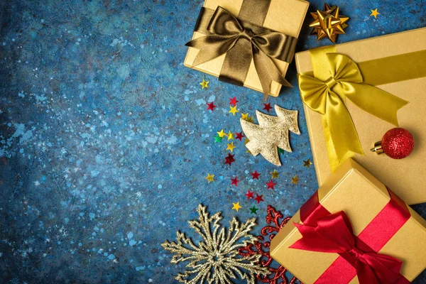 Zlaté dárkové krabice s lesklými saténovými luky a vánoční ozdobou — Stock fotografie