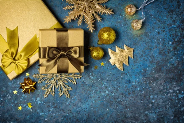 Zlaté dárkové krabice s lesklou hnědou saténovou mašlí a vánoční ozdobou — Stock fotografie