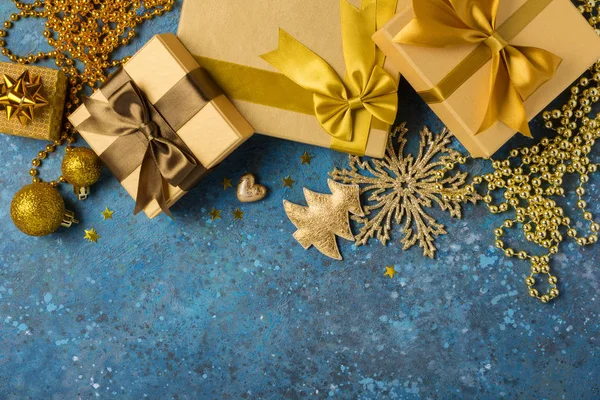 Cajas de regalo de oro con brillante arco de satén marrón y decoraciones de Navidad — Foto de Stock