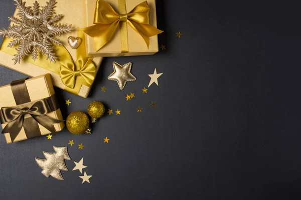 Cajas de regalo de oro con brillante arco de satén marrón y decoraciones de Navidad — Foto de Stock