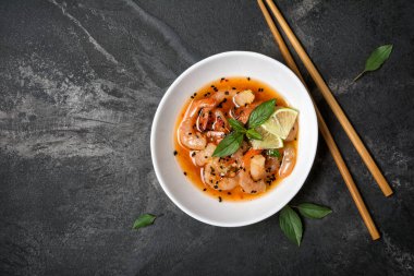 Turuncu Asya soslu baharatlı karidesli kasenin üst görüntüsü limon ve siyah susam tohumları mermer arka planda fotokopi alanı ile