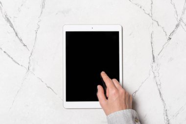 Evde ya da beyaz mermer arka planda web sayfası ile çalışmak için modern tabletin ekranına dokunur