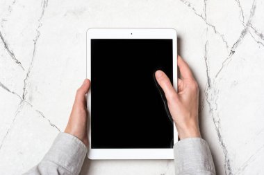 Evde ya da beyaz mermer arka planda web sayfası üzerinde çalışmak için modern tableti tutan eller