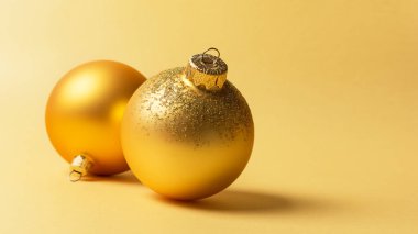Noel ya da yeni yıl süsü. Altın arkaplanlı parlak altın noel toplarının fotokopi alanı ile yakın çekimi