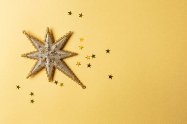 Yeni yıl partisi için dekorasyon. Altın zemin üzerinde, fotokopi alanı olan noel ağacı için güzel, parlak bir yıldız.