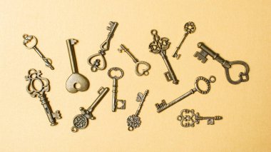 Altın kağıt arka planda eski anahtar koleksiyonunun üst görüntüsü. Gizli, güvenli ya da yeni hayatın anahtarı kavramı